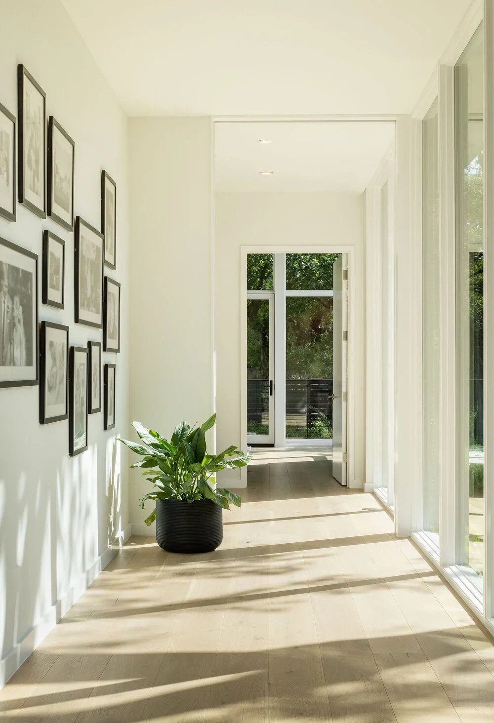 Backyard geometric pool seen through floor-to-ceiling windows, with drapes and abstract artwork