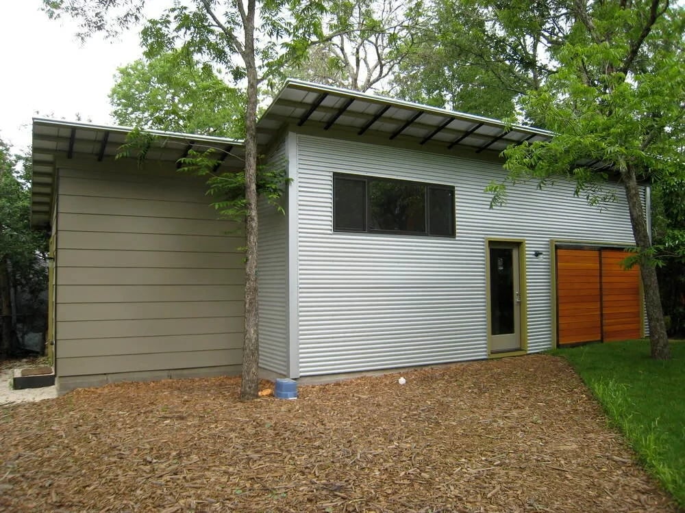 Modern home with horizontal siding, metal roof and clerestory windows among trees