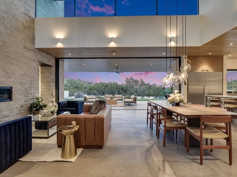 Covered patio with wood ceiling, rope sofas and a linear fireplace opening to the living room