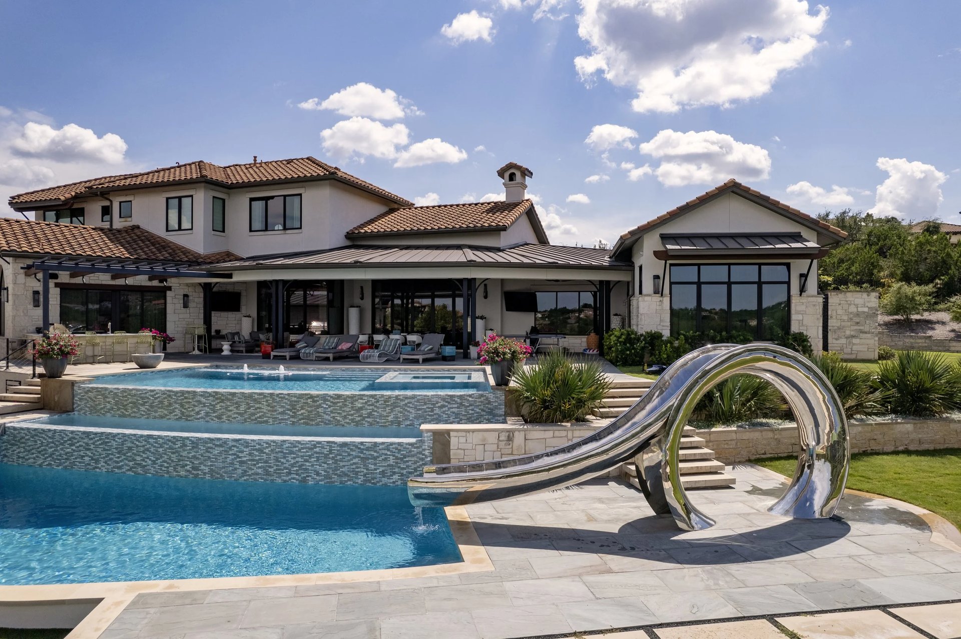 Aerial view of a freeform lagoon style pool on a wooded Austin Hill Country lot