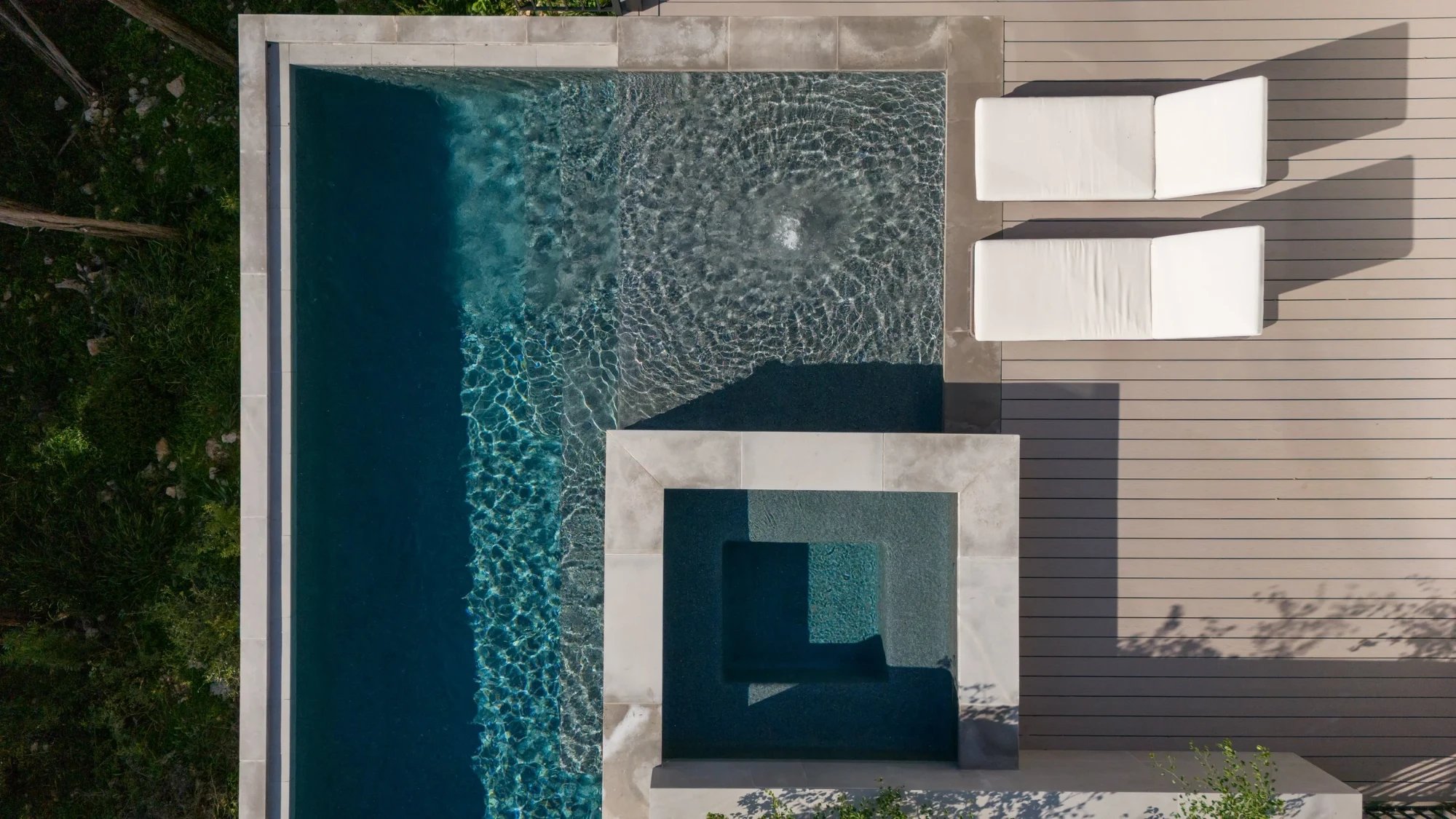 Aerial view of a modern Austin pool and spa, an example of a restored backyard after concrete cancer repair